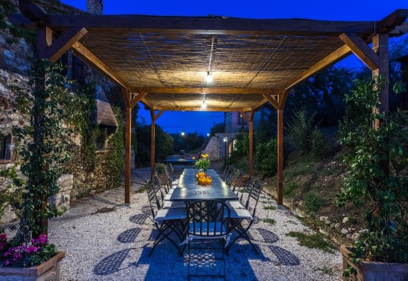 La zona pranzo esterna sotto la pergola illuminata di notte - Villa Poggiente