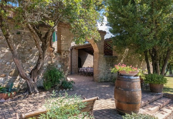 La corte davanti all’ingresso principale, all’ombra di un porticato è allestita la zona pranzo con tavoli e sedie- Villa Poggio Bonelli