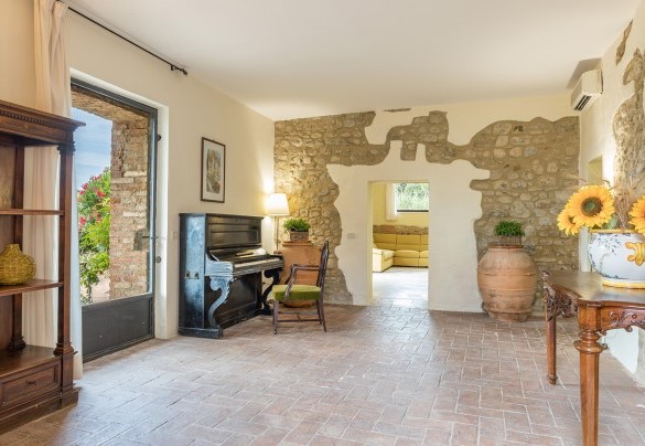 Il largo salone organizzato con area salotto e tavolo da pranzo- Villa Poggio Bonelli