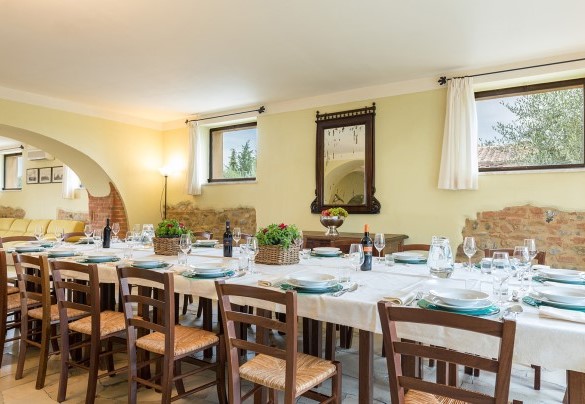 Il largo salone organizzato con area salotto e tavolo da pranzo- Villa Poggio Bonelli
