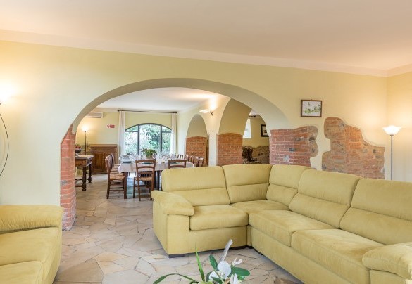 Il largo salone organizzato con area salotto e tavolo da pranzo- Villa Poggio Bonelli