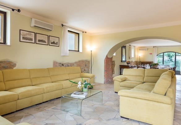 Il largo salone organizzato con area salotto e tavolo da pranzo- Villa Poggio Bonelli