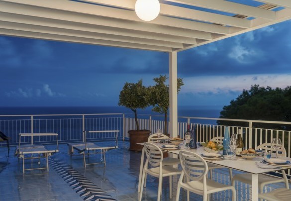 An electronically controlled tent shelters the table from the sun - Villa Ponti