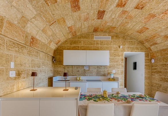 Cucina dell’annesso impreziosita da soffitti e pareti in pietra a vista – Villa Porta Azzurra
