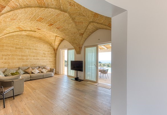 Il design attuale si fonde e armonizza con la pietra a vista del salotto - Villa Porta Azzurra