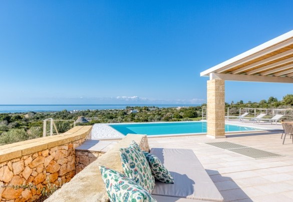 La piscina a sfioro regna nel centro della proprietà e si sviluppa frontalmente alla zona living del corpo principale dal quale dista solo pochi passi - Villa Porta Azzurra