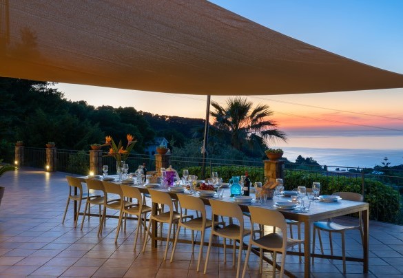 La zona pranzo esterna illuminata di sera al tramonto – Villa Provenza