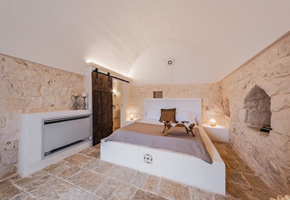 La camera matrimoniale n.5 del trullo con il suo caratteristico letto in muratura – Villa Puspo