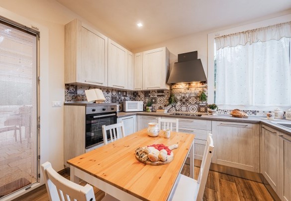 La cucina piccola ma ben accessoriata è collegata alla sala da pranzo e all’esterno attrezzato – Villa Puspo