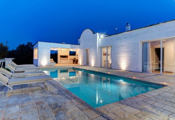 Piscina e area solarium in veste notturna – Villa Puspo