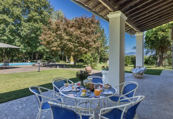 Il portico fresco e ombreggiato con la tavola da pranzo esterna – Villa Rasena 