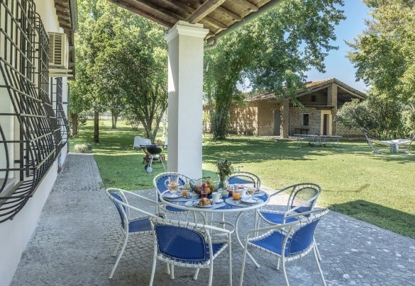 Il portico ombreggia il tavolo preparato per colazioni all’aperto – Villa Rasena 