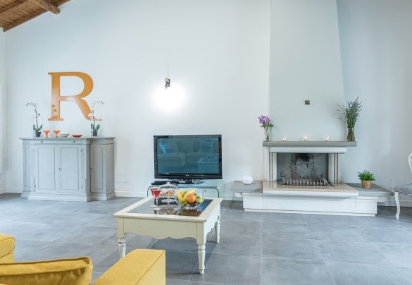 La zona salotto con caminetto e Tv – Villa Rasena 