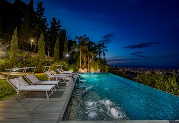 La piscina circondata da piante sempre verdi-Villa Relax
