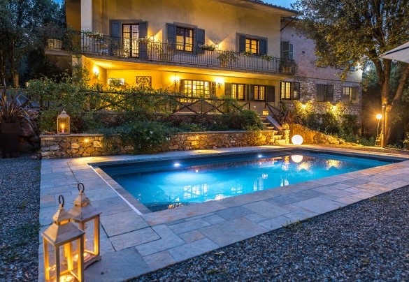 Panoramic view of the pool and the equipped area illuminated by spotlights -Villa Rinaldi