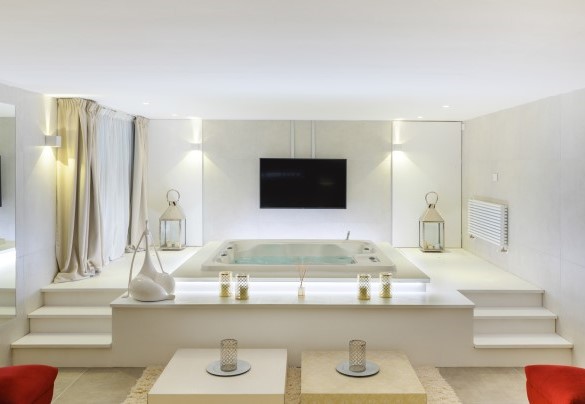 Sala relax con jacuzzi per 5 persone, un ampio divano e maxi schermo – Villa Rossa