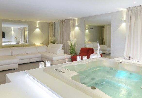 Sala relax con jacuzzi per 5 persone, un ampio divano e maxi schermo – Villa Rossa