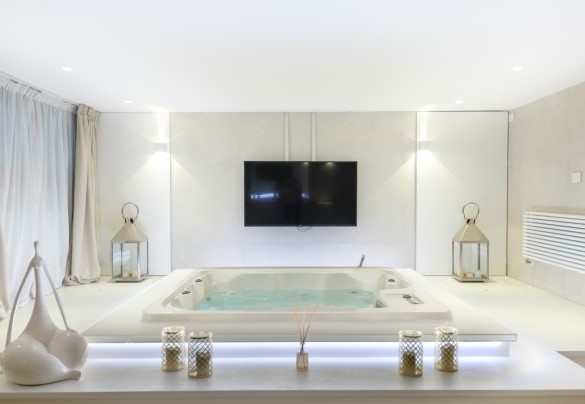 Sala relax con jacuzzi per 5 persone, un ampio divano e maxi schermo – Villa Rossa