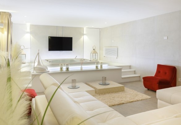 Sala relax con jacuzzi per 5 persone, un ampio divano e maxi schermo – Villa Rossa