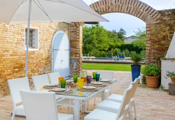  Nella zona pavimentata perimetrale, troviamo un bellissimo tavolo dove è possibile consumare pranzi o cene all’aperto e un comodo divano con poltrone e tavolino dove godersi splendidi aperitivi serali – Villa Rustica