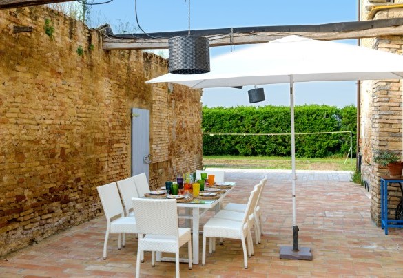  Nella zona pavimentata perimetrale, troviamo un bellissimo tavolo dove è possibile consumare pranzi o cene all’aperto e un comodo divano con poltrone e tavolino dove godersi splendidi aperitivi serali – Villa Rustica