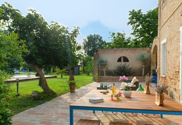  Nella zona pavimentata perimetrale, troviamo un bellissimo tavolo dove è possibile consumare pranzi o cene all’aperto e un comodo divano con poltrone e tavolino dove godersi splendidi aperitivi serali – Villa Rustica