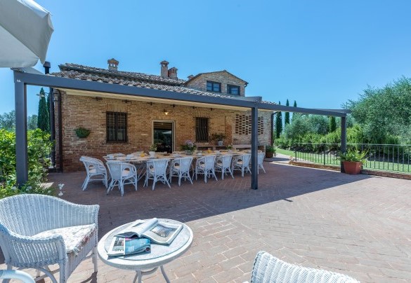 L’area colazione ombreggiata da una pergola e un’area salotto- Villa San Nazario