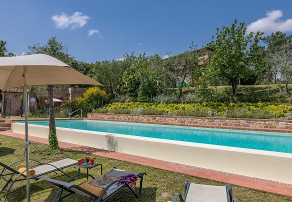 La piscina a sfioro incorniciata dal parco della proprietà al limitare del vigneto e dell’oliveto – Villa Santa Maria