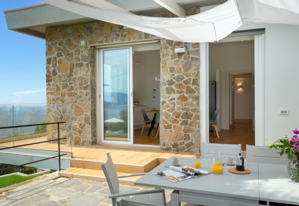 La terrazza unisce il vetro il legno e la pietra - Villa Scirocco