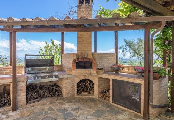 La suggestiva pergola ombreggiata da gelsomini e attrezzata con forno a legna e barbecue- Villa Siena