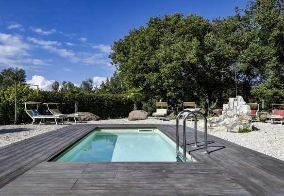 The pool with pool terrace on deck surrounded by white river gravel - Villa Sparta