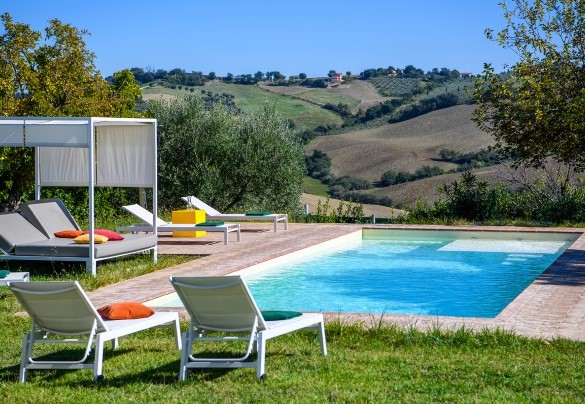 The pool terrace equipped with sun loungers and canopy bed  – Villa Traiani