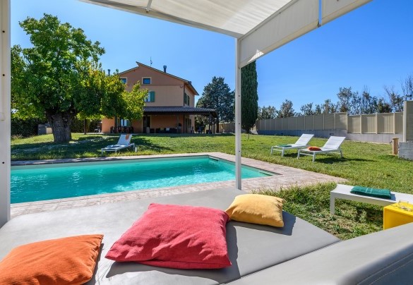 Poolside loungers and daybed with view of the villa – Villa Traiani