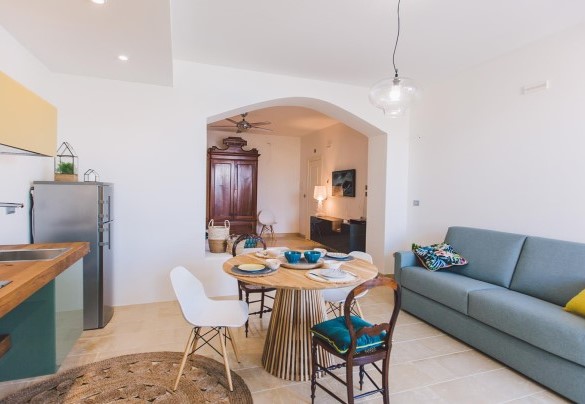 double bedroom with round bed, kitchen and en suite bathroom - Villa Triscele