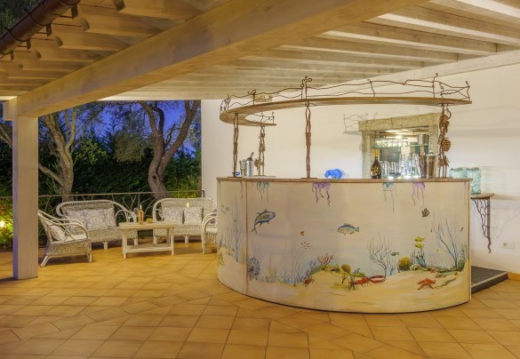 Angolo relax arricchito da un bancone bar e divanetti – Villa Typha