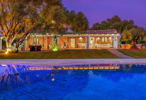 Vista al tramonto della villa e della piscina illuminate – Villa Typha