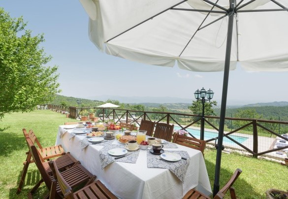 Dining area protected by a large umbrella - Villa Vittoria D'Anghiari