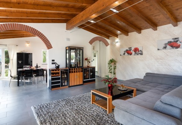 Il soffitto con le travi di legno e gli archi coi mattoni a vista si integrano con armonia al moderno e funzionale arredamento - Villa Vittorio