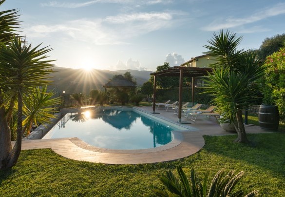 La pavimentazione in pietra separa la piscina dal grande prato - Villa Vittorio