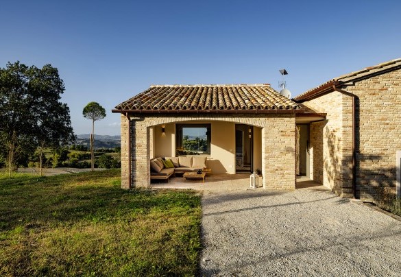 Loggia d'ingresso con divano ad angolo e vista panoramica – Villa Zenit