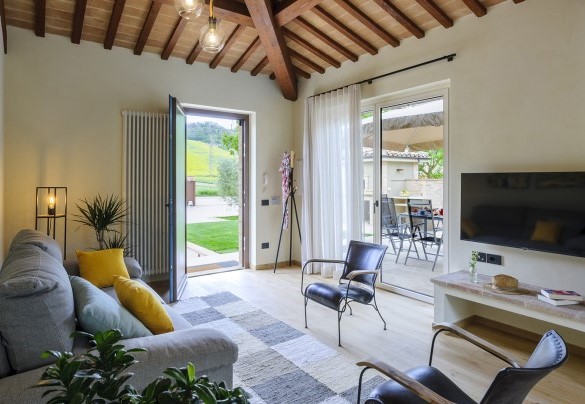 The living area furnished with sofas, TV and fireplace - Villino Le Moie