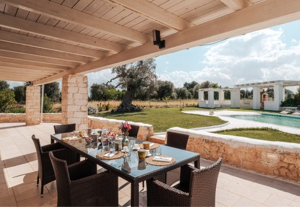 The dining area under the outdoor pergola - White Stone House